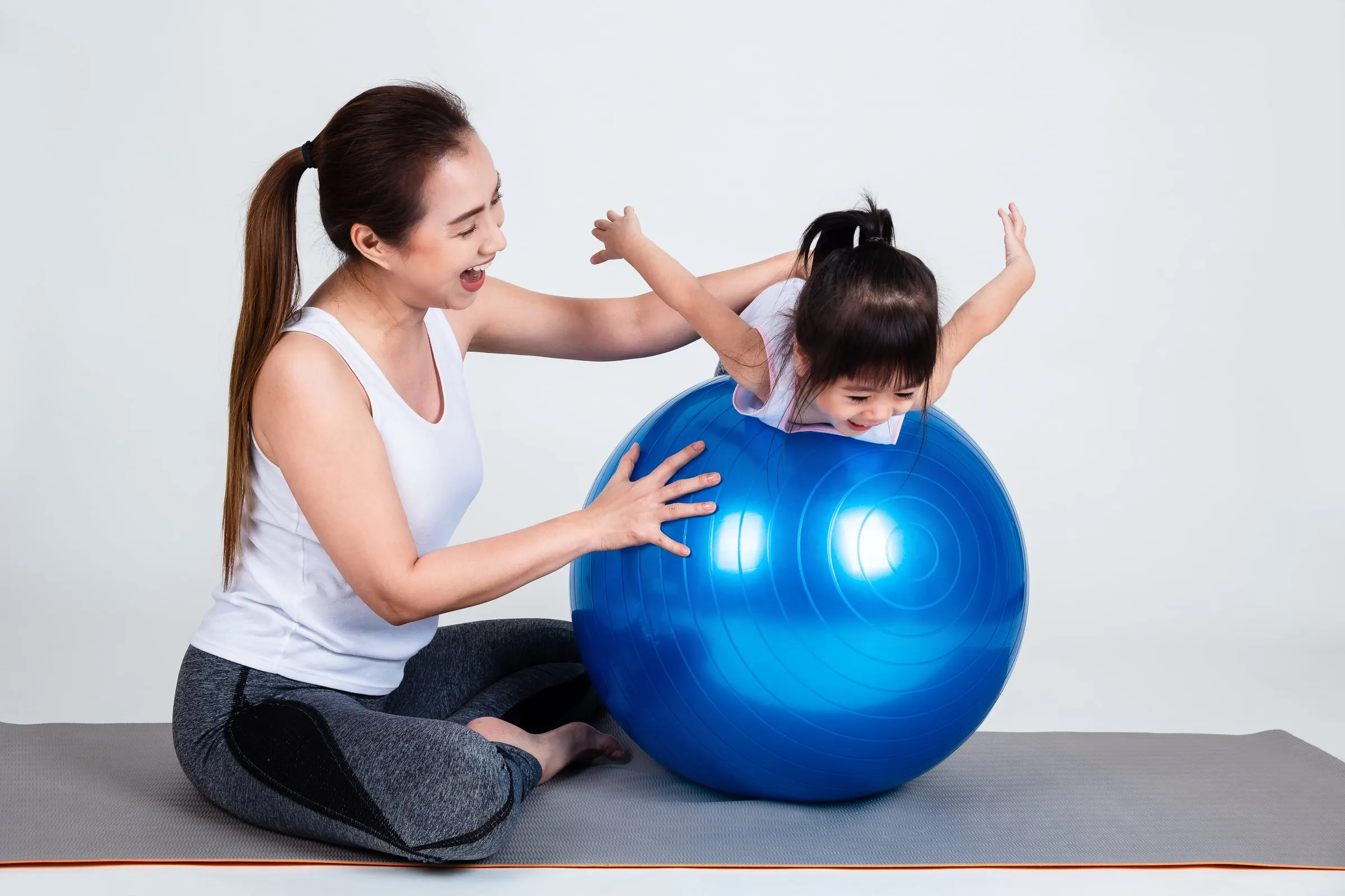 Fizyoterapist bir çocukla pilates topu üzerinde denge çalışıyor